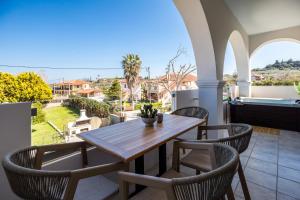 a table and chairs on a balcony with a view at Mamfredas Suites in Kypseli