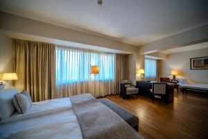 a hotel room with a bed and a living room at Hotel Rivo Timisoara in Timişoara
