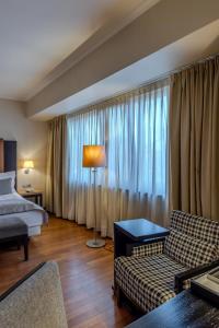 a living room with a couch and a bed at Hotel Rivo Timisoara in Timişoara