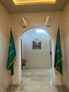 a hallway with two clocks and two flags on the wall at شقق خزامى الباحة in Al Baha