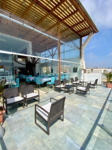 a patio with chairs and tables on a building at Mochican Palace Hotel in Huanchaco