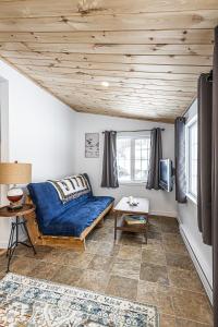 a living room with a couch and a table at Cozy Lakeside Cottage in Val des Monts
