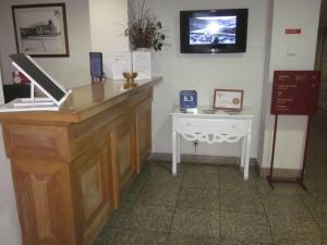 a living room with a tv and a desk at Pousada Barão de Forrester in Alijó