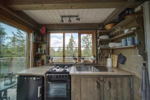 a kitchen with a sink and a stove and a window at Faråsen Luxury Treetop Cabin - Sleep Among the Trees in Ringsaker