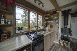 a kitchen with a stove and a sink and some windows at Faråsen Luxury Treetop Cabin - Sleep Among the Trees in Ringsaker