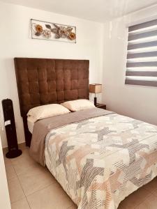 a bedroom with a large bed with a brown headboard at Departamento-Poliforum Feria Estadio Zona Piel. in León +12 photos