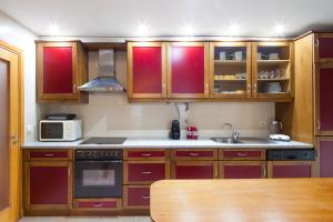 a kitchen with wooden cabinets and a sink and a microwave at Oceanos premium apartment in Ovar