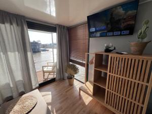 圣玛丽亚港Casa Flotante El Refugio del Pirata的客厅设有大窗户和电视。
