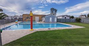 a swimming pool in a yard with a playground at Whitstable Beaumont - Sleeps 6, 588 ft in Seasalter