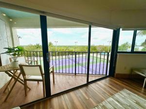 a large room with a balcony with a table and chairs at Villa Valbuena Gem Key Largo 2 Kings Marina Pickleball Tennis 3 Pools Remodeled 2025 in Key Largo