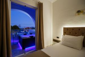 a bedroom with a window with a view of a balcony at Mamfredas Suites in Kypseli +29 photos