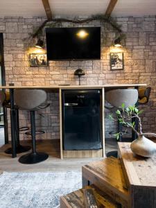a living room with a tv on a brick wall at FeWo Ottobeurens Schmuckstück Gemütlich-Stylische Wohnung - AMETHYST in Ottobeuren