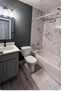 a bathroom with a toilet and a tub and a sink at Banff mountain House&30 second Bus station Close C-Train& Free Parking in Calgary