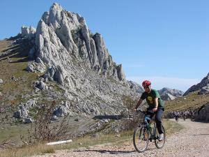 a man riding a bike on a mountain road at Rooms & Pansion Odmor in Rovanjska