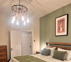 a bedroom with a bed and a chandelier at Ruby Sands in Saltburn-by-the-Sea