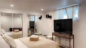 Un dormitorio con un televisor de pantalla plana y una cama. en Cozy Terrebonne, en Terrebonne