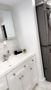 cocina con fregadero y nevera negra en Cozy Terrebonne, en Terrebonne 1 foto más