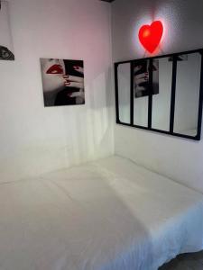 biały pokój z łóżkiem i czerwonym sercem na ścianie w obiekcie Résidence Port Soleil Bâtiment B3 - Studio Cabine 2 pers. Port Soleil CAP d'AGDE MAE-4424 w Cap d'Agde