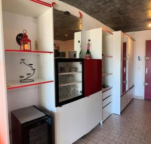 kuchnia z białymi szafkami i czerwonymi i białymi półkami w obiekcie Résidence Port Soleil Bâtiment B3 - Studio Cabine 2 pers. Port Soleil CAP d'AGDE MAE-4424 w Cap d'Agde