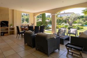 une pièce avec des chaises et des tables et un patio dans l'établissement Villa Indigo, à Saint-Rémy-de-Provence
