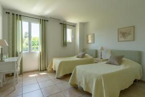 une chambre avec deux lits, une table et une fenêtre dans l'établissement Villa Indigo, à Saint-Rémy-de-Provence 69 autres photos