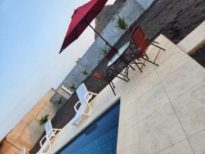 two chairs and an umbrella next to a pool at Villa Sanyolí in La Barrita +9 photos