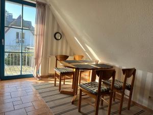 a table and chairs in a room with a window at Wieck - Ferienwohnung EVA & HANSI by Restaurant WIESENAU in Wieck