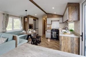 a kitchen and living room with a blue couch at Lakeside Retreat - AGH Hot Tub Breaks - Tattershall Lakes in Tattershall