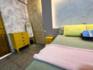 a bedroom with a bed and a yellow dresser at Hermoso Apartamento equipado in Puerto Barrios