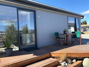 a deck with a table and chairs on a house at Hank's Hut in Lake Tekapo +1 photo