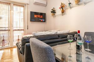 a living room with a couch and a table with wine glasses at Elegante bilocale AC, WiFi ,5 min Policlinico, 25 min Duomo Milano in San Donato Milanese