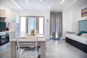 una cucina e una sala da pranzo con un tavolo e un letto di Affittacamere - Rosa dei venti a Porto SantʼElpidio