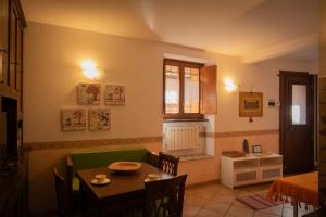 a small dining room with a table and a kitchen at Casa per vacanze Antico Forno in Sutri