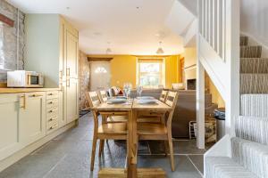 a kitchen and dining room with a wooden table and chairs at Luxurious Cosy Cottage in Buxton