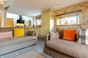 a living room with two couches with colorful pillows at Luxurious Cosy Cottage in Buxton