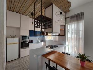 a kitchen with white cabinets and a wooden table at Superior Apartment Near Beach in Chania +20 photos