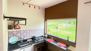 a kitchen with a sink and a window at Chácara Itaqueri Rubi in São Pedro