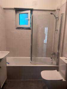 a bathroom with a tub and a toilet and a window at Casa da Rita in Cascais