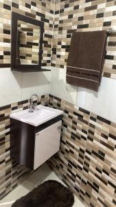 ein Badezimmer mit Waschbecken und einem Handtuch an der Wand in der Unterkunft Descanso Vista Alegre in Campos do Jordão