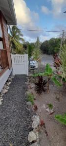 a backyard with a white fence and some plants at Kay Soley La in Saint-François