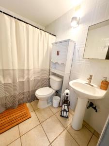 a white bathroom with a toilet and a sink at Beachfront at Cabo Rojo in Cabo Rojo +14 photos