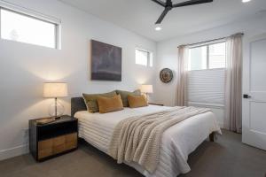 a bedroom with a large bed and two windows at Cozy Modern Cabin W Hot Tub - Minutes To Ski Area in Winter Park +28 photos