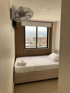 a small bedroom with a bed and a window at Hotel Tonchala Centro in Armenia