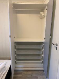 un vestidor con paredes y estanterías blancas en 2-bedroom, walking distance to the city center, en Drammen