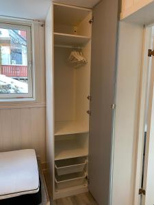 Un dormitorio con un armario con estantes y una ventana. en 2-bedroom, walking distance to the city center, en Drammen