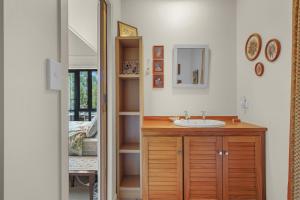 a bathroom with a sink and a mirror at Karearea Cottage - Rural Retreat Purau in Purau +25 photos