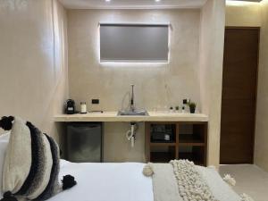 een badkamer met een wastafel en een bed in een kamer bij Holbox Midtown Suites in Holbox Island +18 foto's