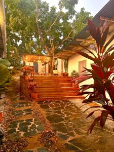 a house with a porch with wooden stairs in a yard at HOTEL RENASCI PALOMINO in Palomino