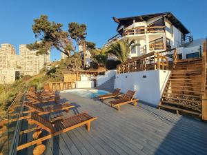 eine Terrasse mit Holzstühlen und ein Gebäude in der Unterkunft Maré Hotel Boutique in Viña del Mar