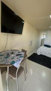 Cette chambre comprend une table, un lit et une télévision à écran plat. dans l'établissement Águas cristalinas 01, à Cabo Frio